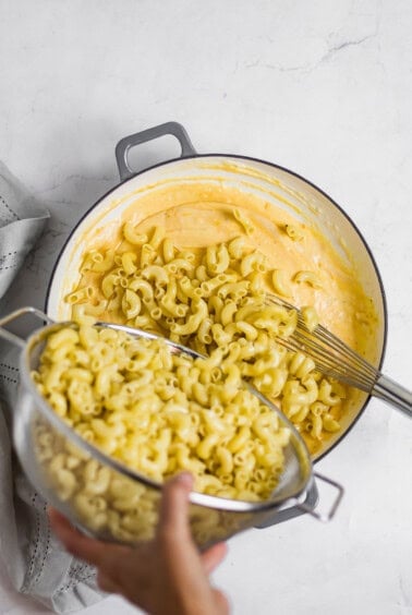 adding noodles to pot.