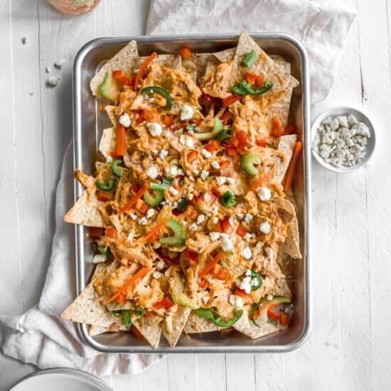 Buffalo chicken nachos on a baking sheet.