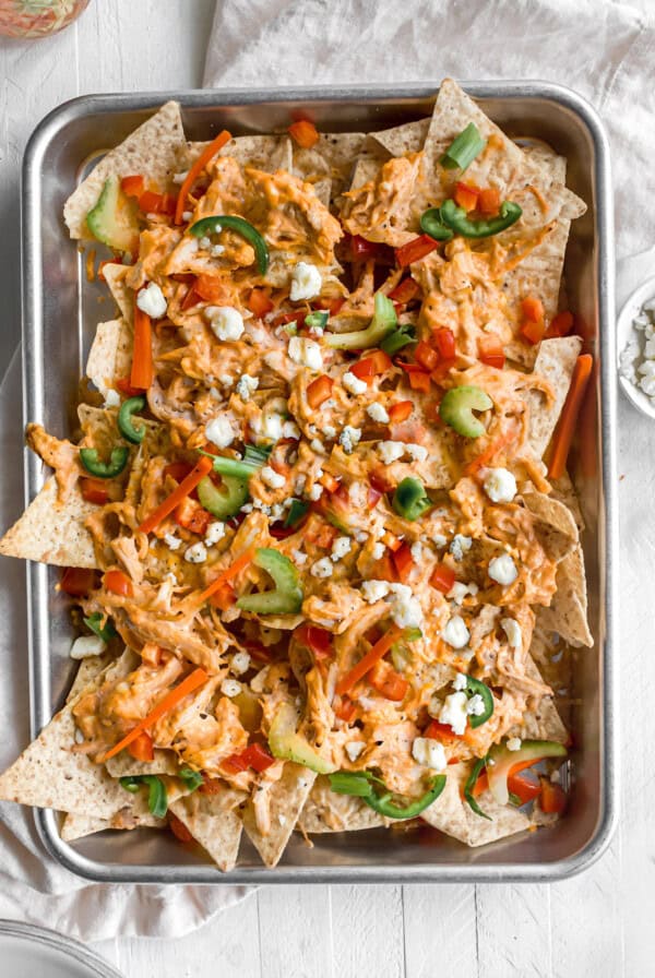 Buffalo chicken nachos on a baking sheet.