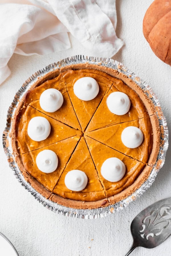 A slice of pumpkin cheesecake with whipped cream.