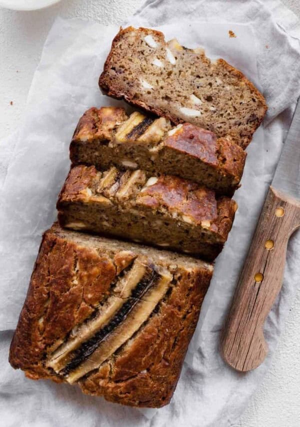 a close up image of cream cheese banana bread cut into slices