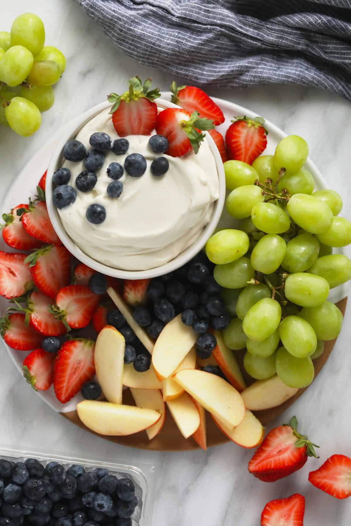 cream cheese fruit dip surrounded by fresh fruit on a plate