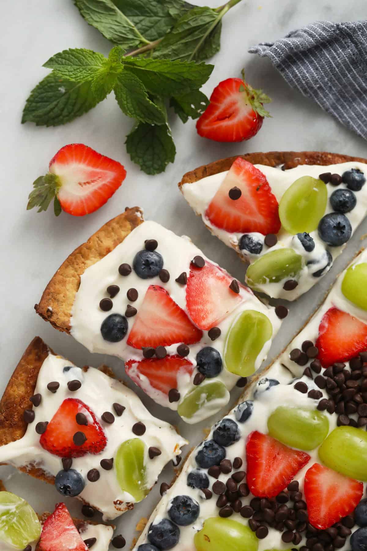 Finished fruit pizza on a cutting board. 