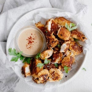 a plate with chicken nuggets and dipping sauce.