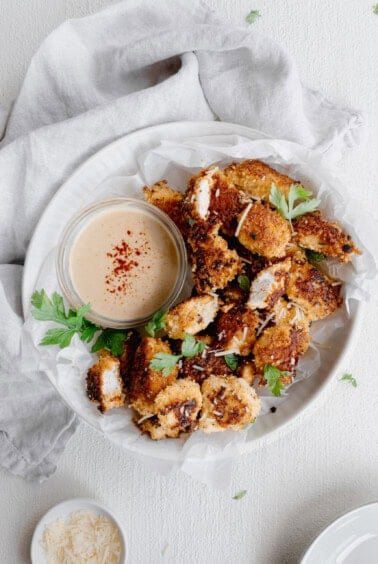 a plate with chicken nuggets and dipping sauce.