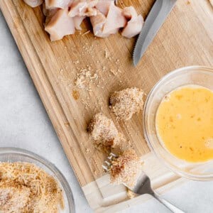 A cutting board with chicken nuggets for chicken fried rice.