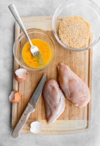 A cutting board with chicken nuggets and seasonings.