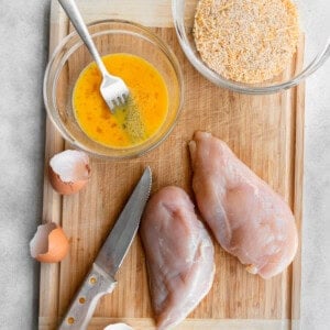 A cutting board with chicken nuggets and seasonings.