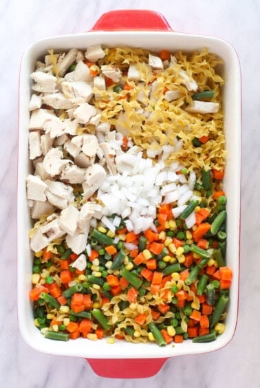 Creamy chicken noodle casserole served in a red baking dish.