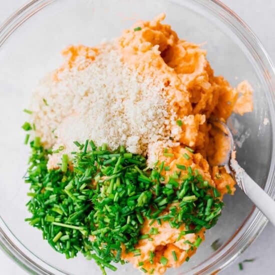 a bowl with leftover cheesy potato pancakes, carrots, parmesan cheese, and parsley.