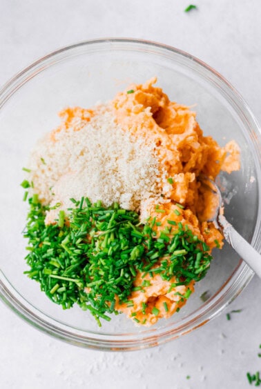 a bowl with leftover cheesy potato pancakes, carrots, parmesan cheese, and parsley.