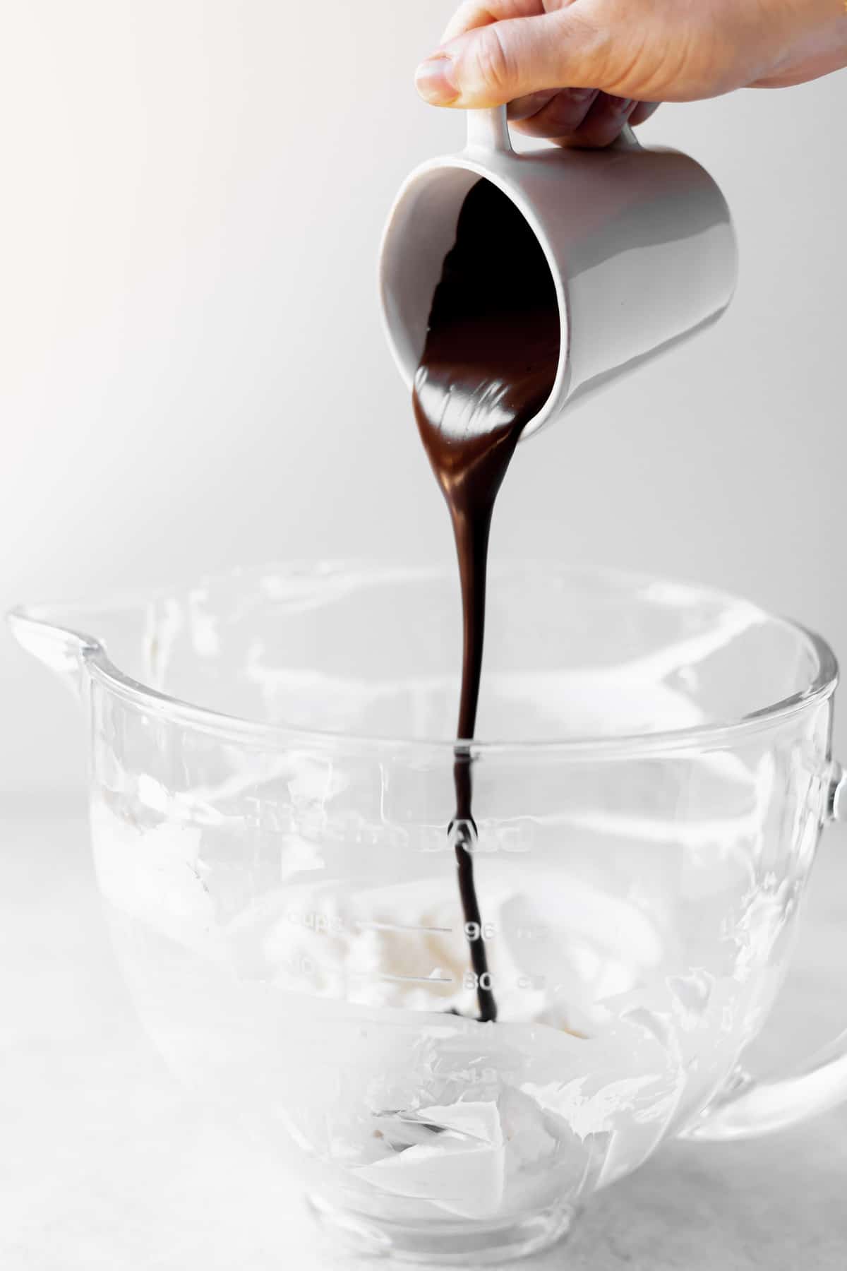 Pouring melted chocolate into cream cheese. 