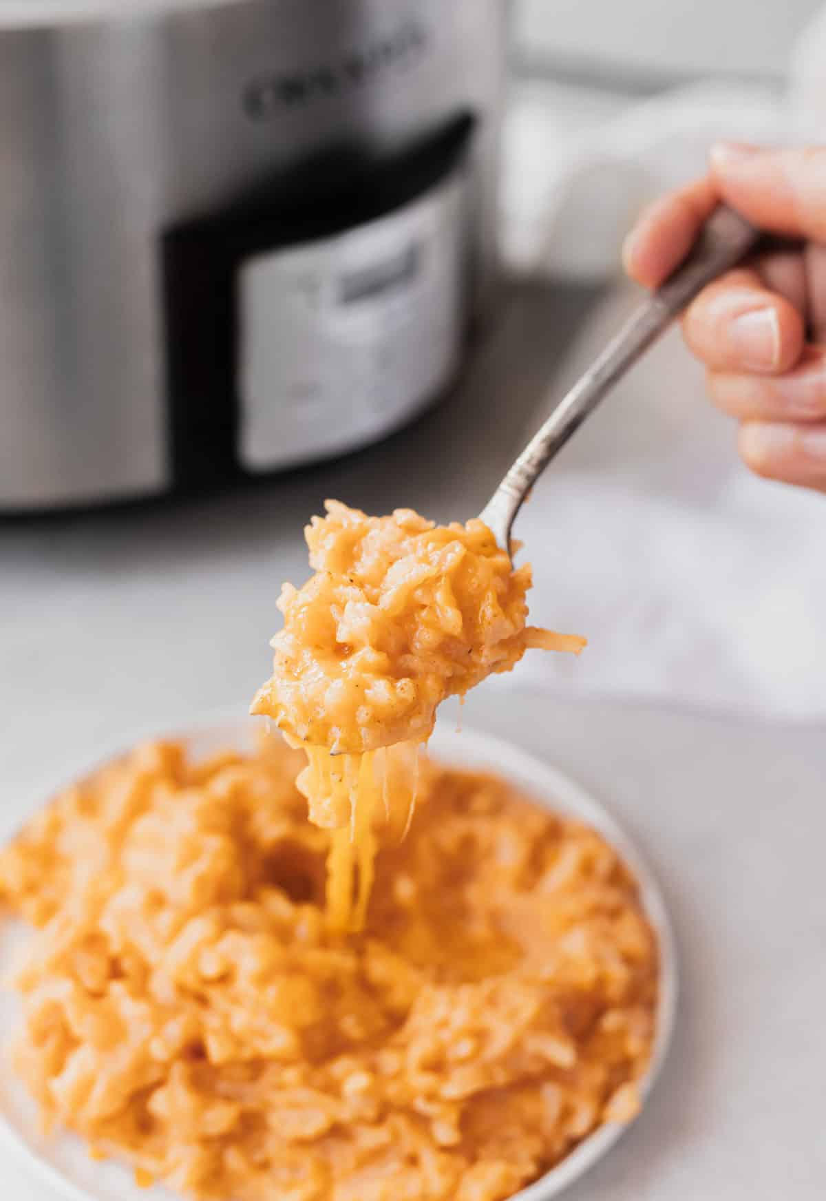 easy crockpot cheesy potatoes on plate with fork