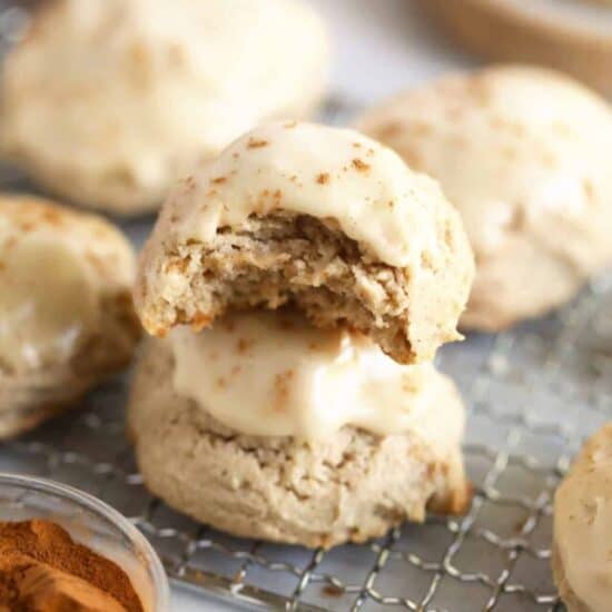 2 pumpkin spice cream cheese cookies stacked on a cooling rack