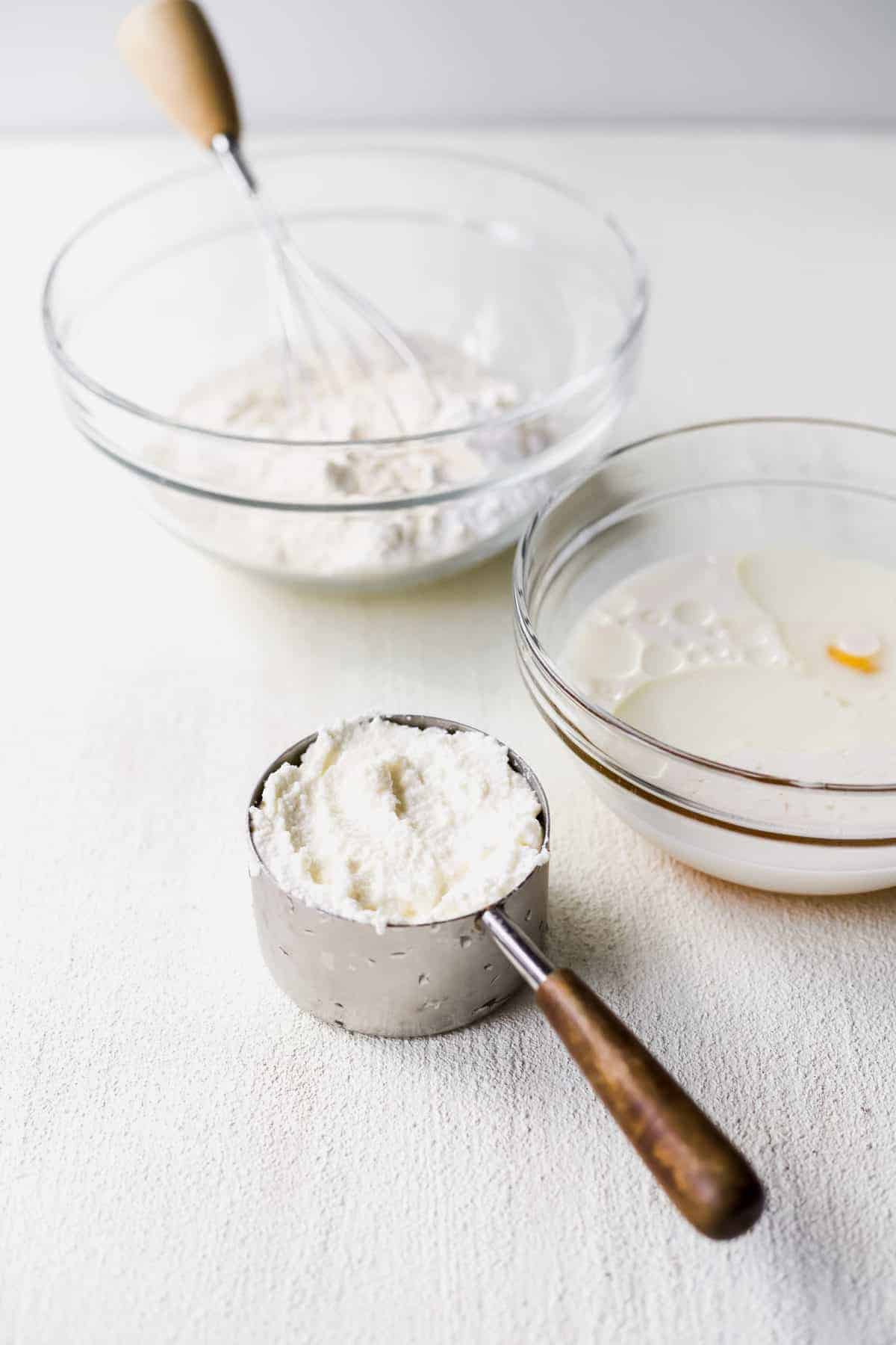 Ricotta pancakes ingredients in bowls ready to be mixed together.