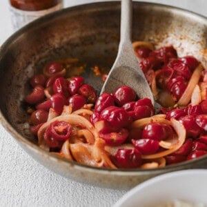 A pan-fried dish showcasing rice and a flavorful cherry sauce, perfect with sun-dried tomato pasta.