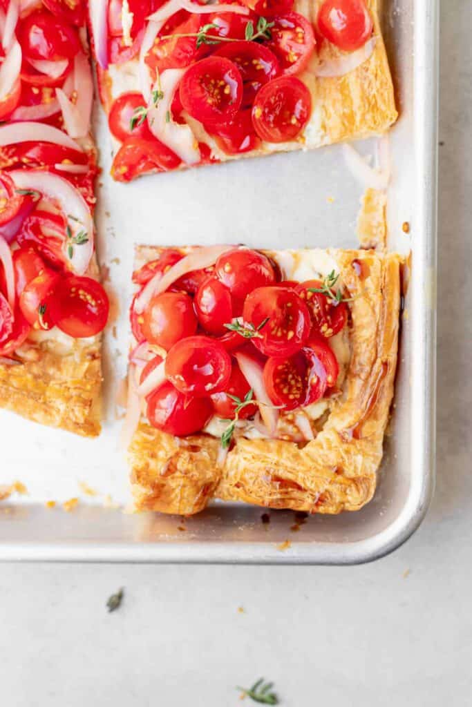 slice of tomato tart on a baking sheet ready to be enjoyed.