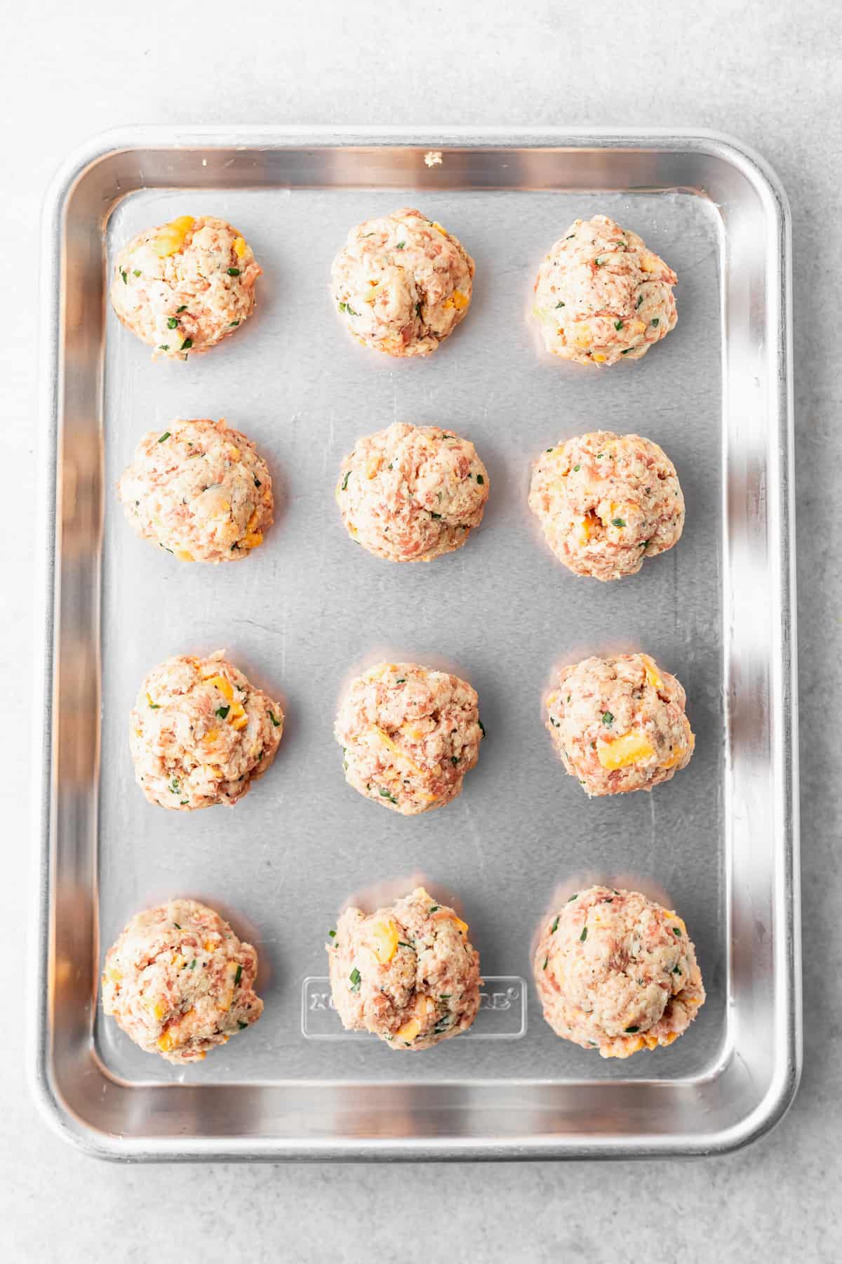 raw cream cheese sausage balls on a baking tray ready to be cooked