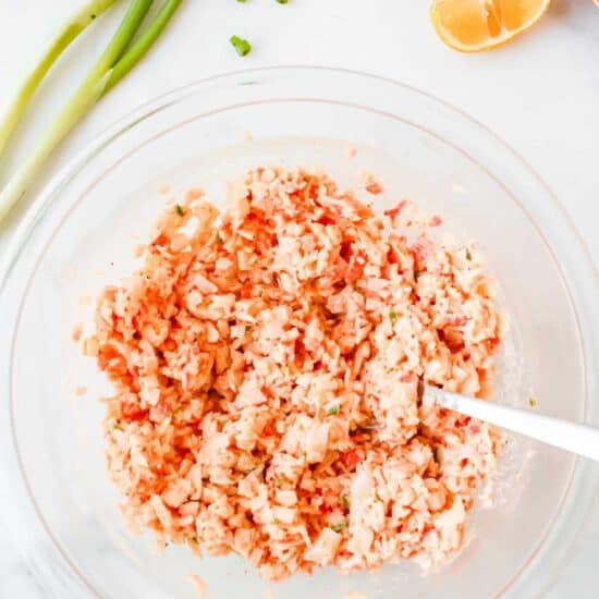 Cold crab dip served with a spoon, presented in a glass bowl.