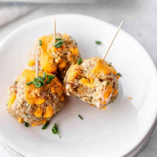 cheesy meatballs on a plate with toothpicks.