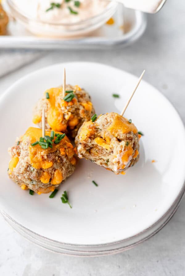 cheesy meatballs on a plate with toothpicks.