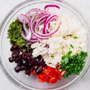 the ingredients for a greek salad in a bowl.