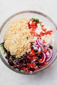 greek rice salad in a glass bowl.