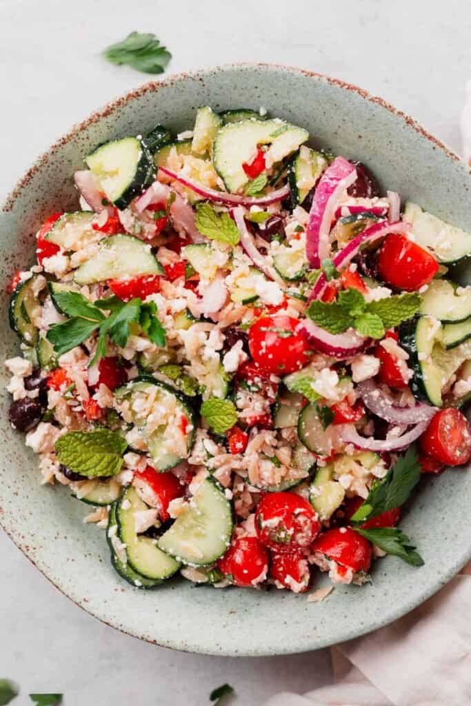 Large bowl of greek salad with orzo and feta.