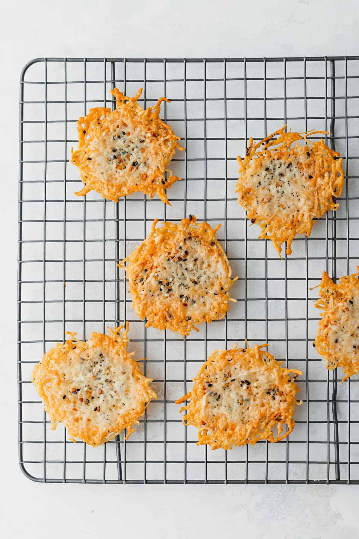 This parmesan crisps recipe is a fantastic 100 calorie snack that you can munch on all day long. Enjoy! cheese crisps on cooling rack