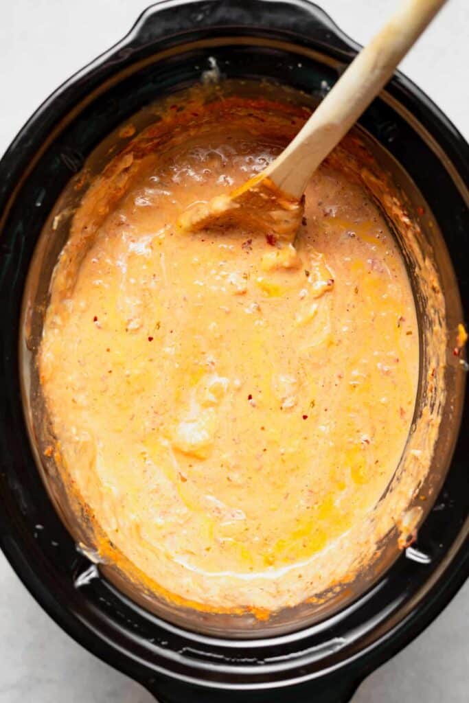 slow cooker queso dip melted in a crock pot and looking delicious.