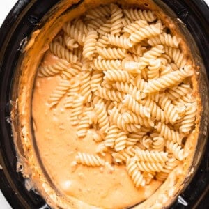 a crock pot filled with pasta and sauce.