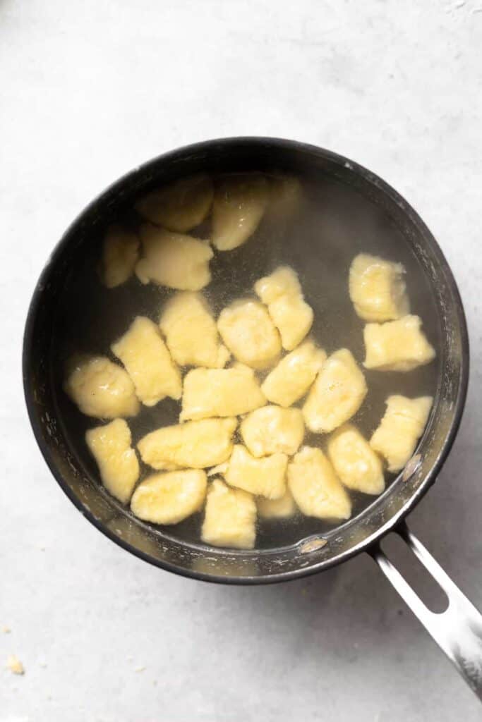 ricotta gnocchi being boiled in a stock pot