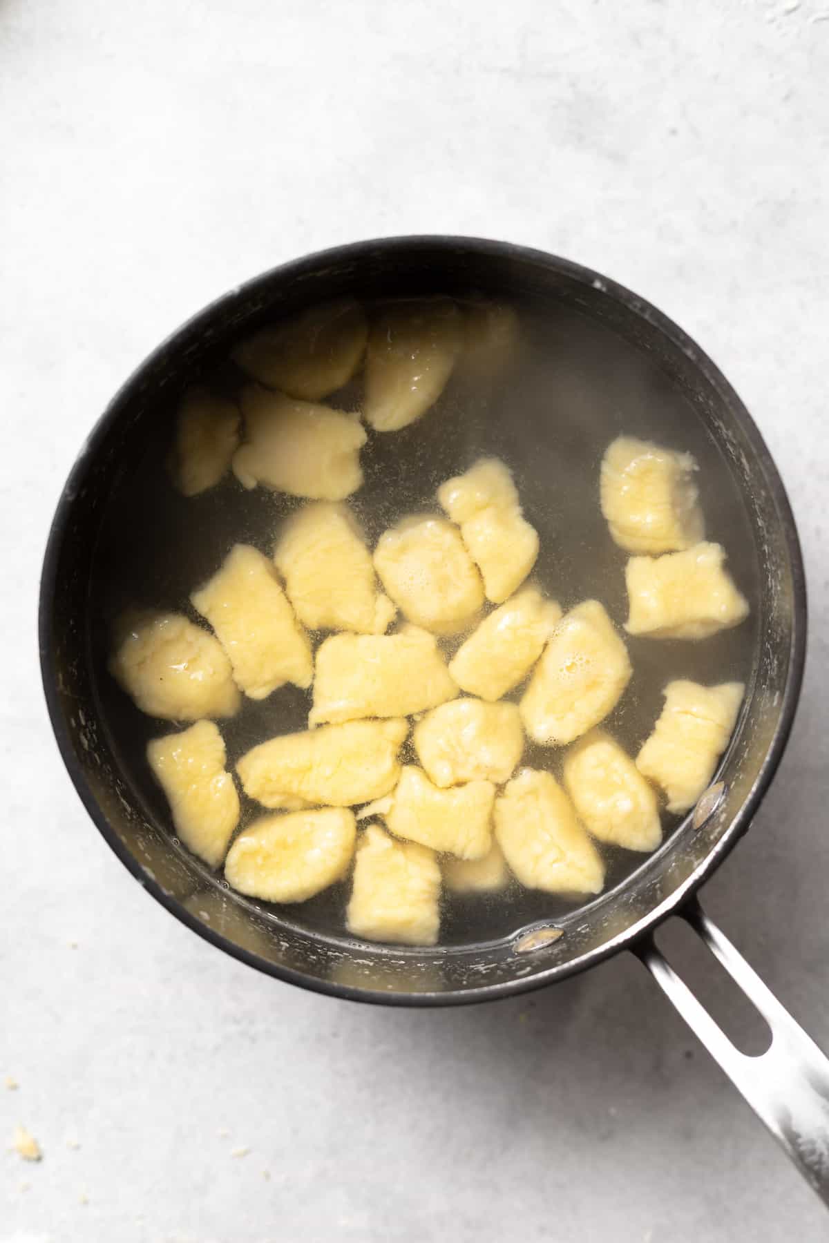 ricotta gnocchi being boiled in a stock pot.