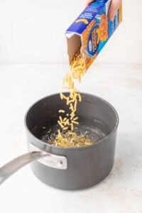 adding noodles to water.