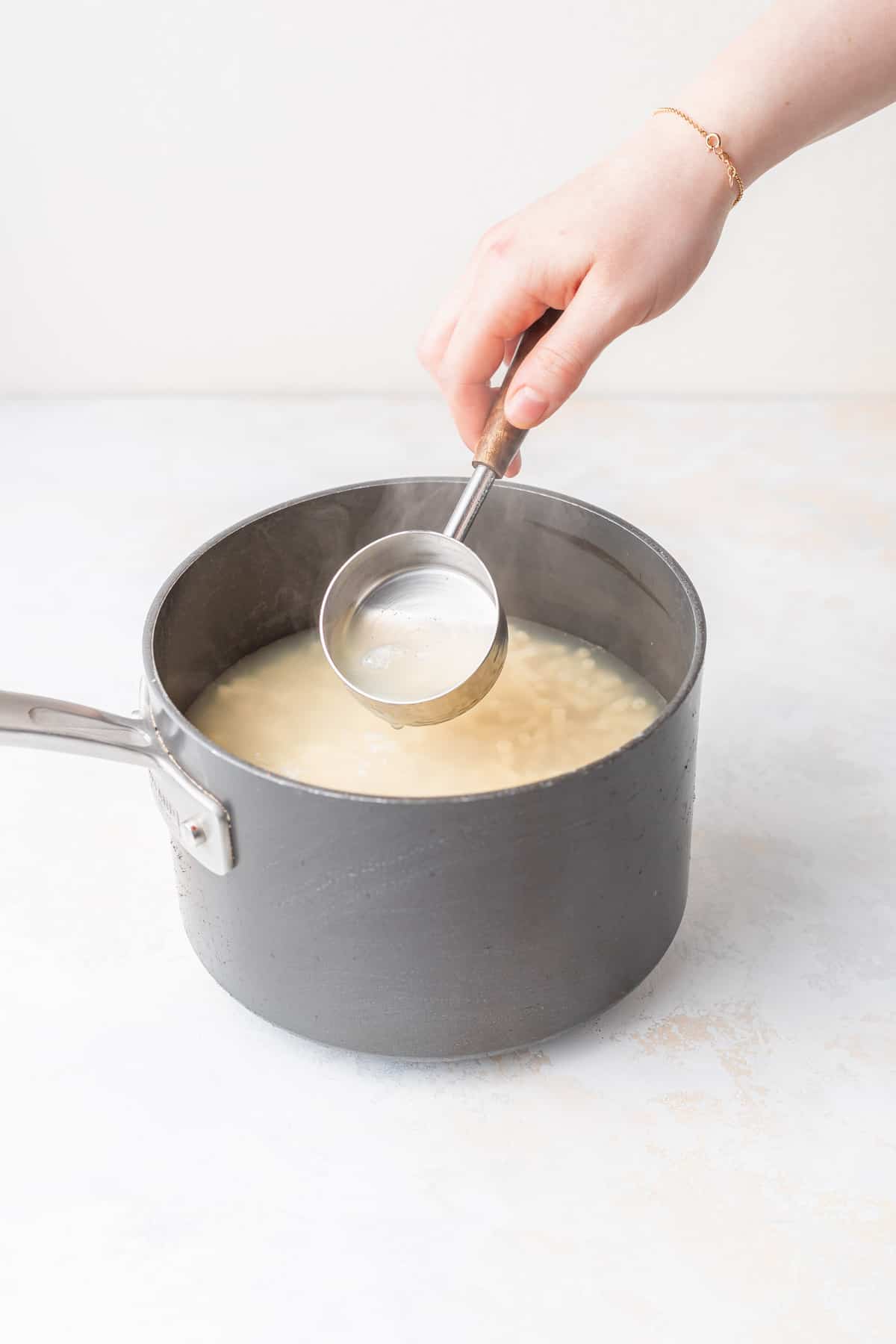 Taking starchy water from a saucepan. 