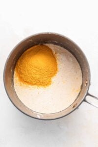 making cheese sauce in pot.