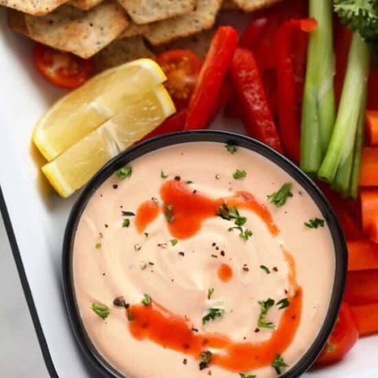 a platter with vegetables and a bowl of buffalo whipped cottage cheese dip