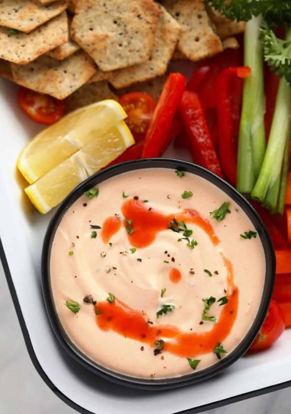 a platter with vegetables and a bowl of buffalo whipped cottage cheese dip