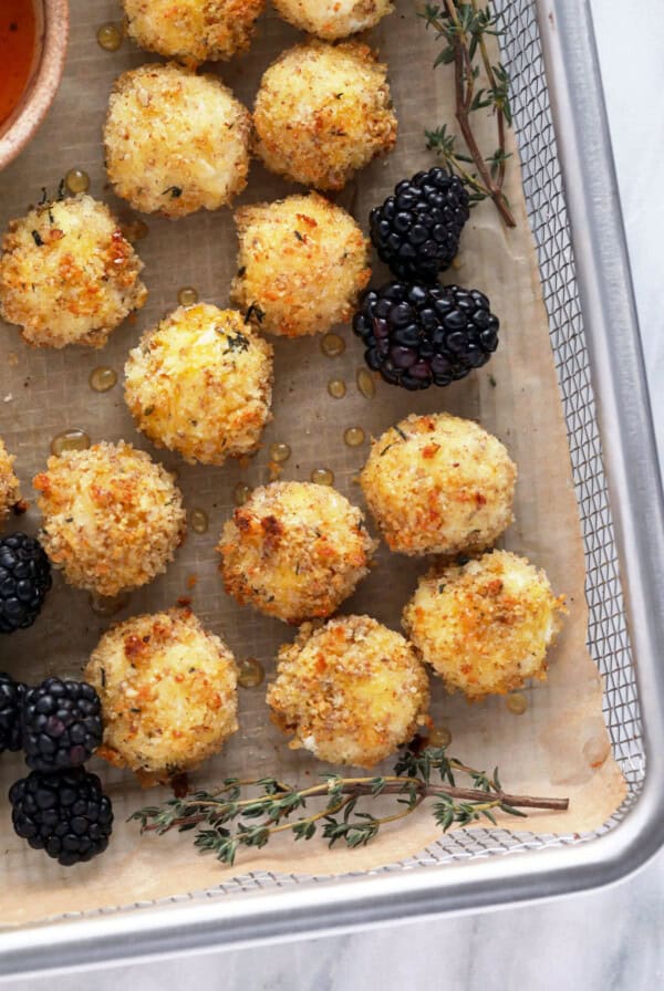 a metal tray topped with blackberries and cheese balls.