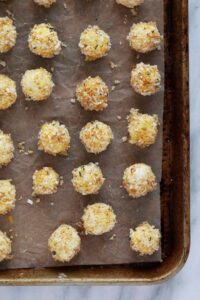 a baking sheet with a bunch of balls of food on it.