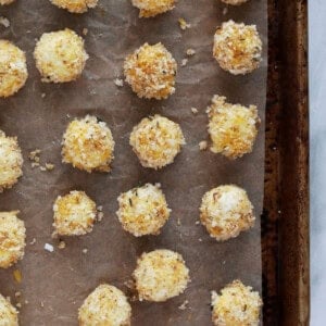 a baking sheet with a bunch of balls of food on it.