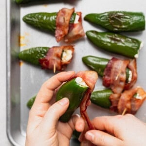 bacon wrapped jalapenos on a baking sheet.