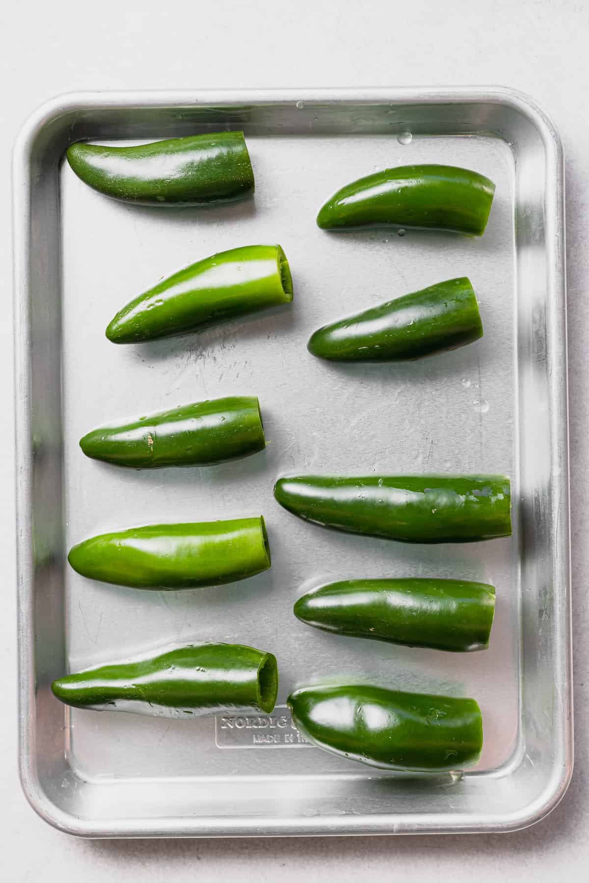 Hallowed out Jalapeño Poppers on baking sheet. 