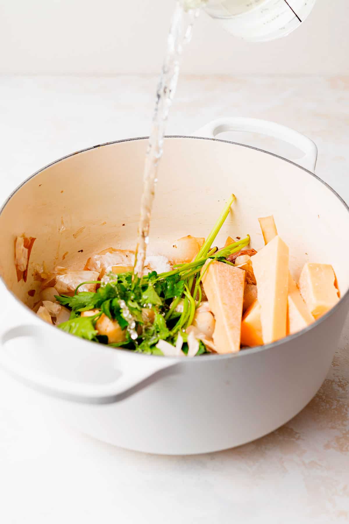 ingredients for parmesan broth in a stock pot, ready to be cooked down