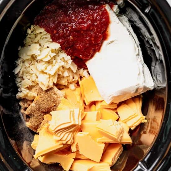 a crock pot filled with cheese and other ingredients.