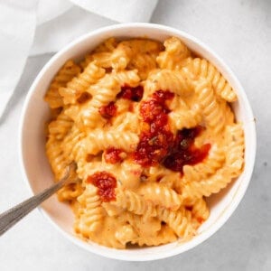 macaroni and cheese in a white bowl with a spoon.