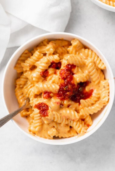 macaroni and cheese in a white bowl with a spoon.