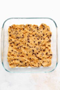 a glass baking dish filled with chocolate chip cookie dough.