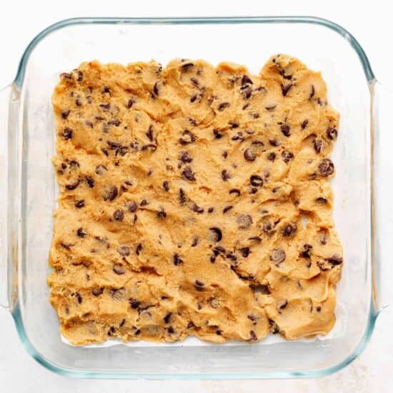 a glass baking dish filled with chocolate chip cookie dough.