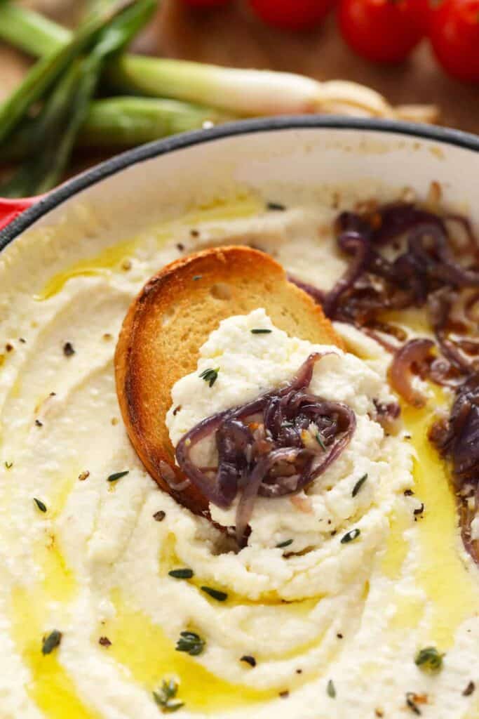 whipped feta dip with a toasted crostini dipped into it